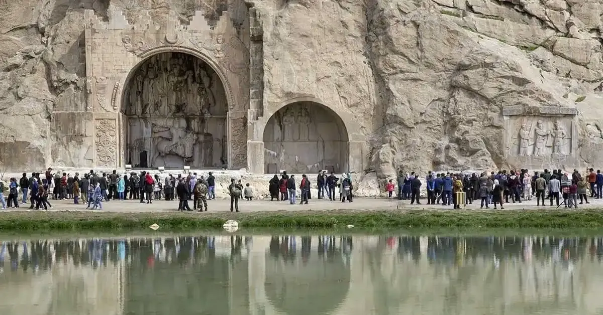 طاق بستان، یکی از جاهای دیدنی کرمانشاه است که  مسافران در حال بازدید از مجسمه‌های ساخته شده دستی در سالیان قدیم در دل کوه می‌باشند