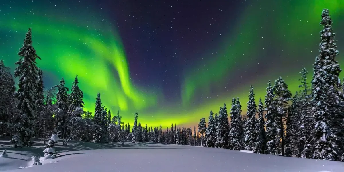 آسمان پرستاره با شفق قطبی سبز و بنفش در منطقه مورمانسک روسیه